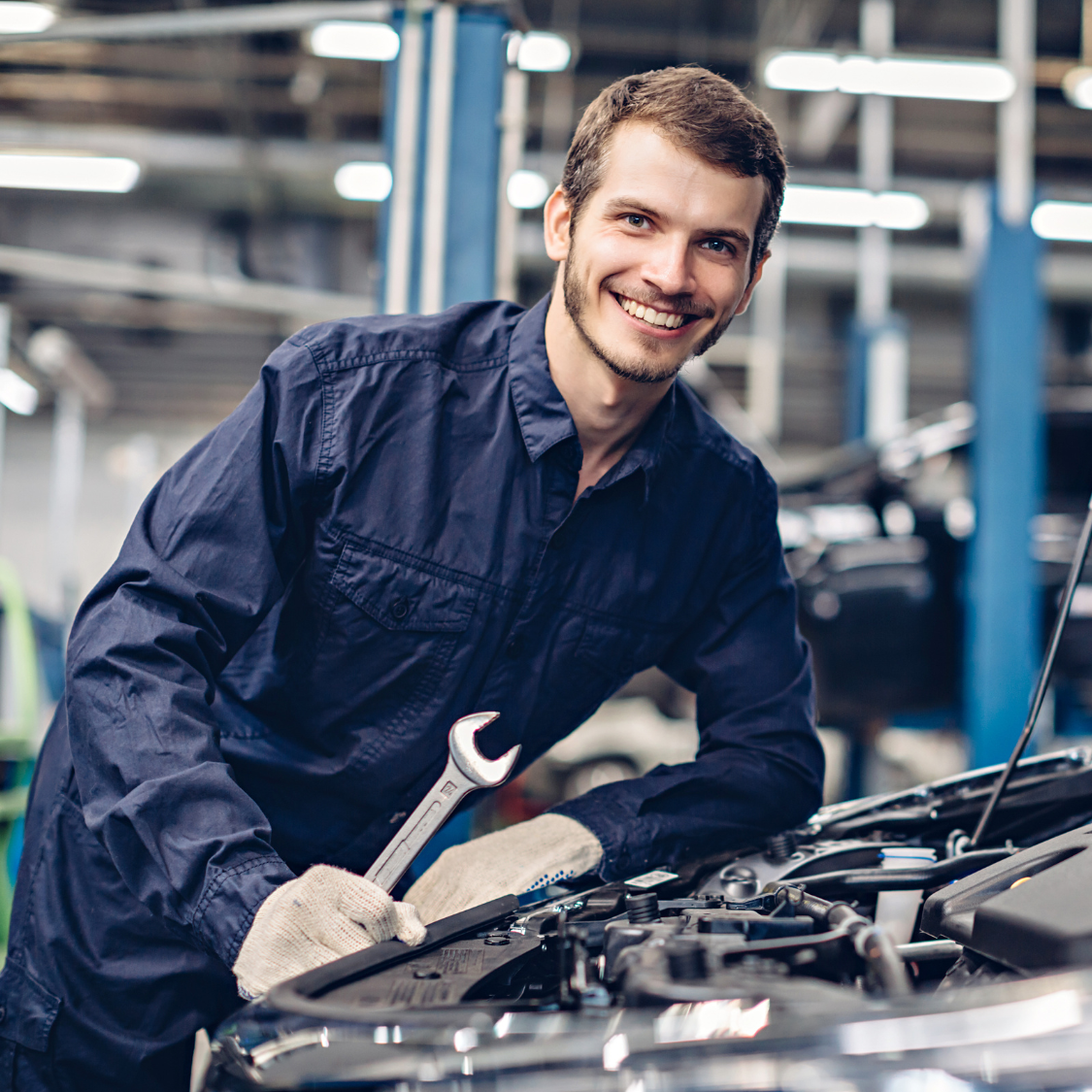 Happy mechanic working on a car